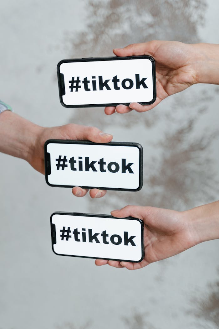 services-img-04 Hands holding smartphones displaying TikTok hashtag, emphasizing social media connection.